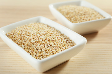 Bowls with quinoa seeds on wooden table