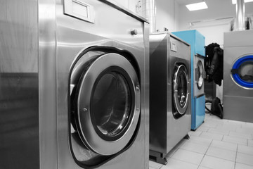 Industrial laundry washing machines in dry cleaner's workshop