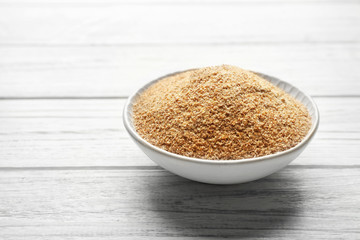Small bowl of bread crumbs on wooden background