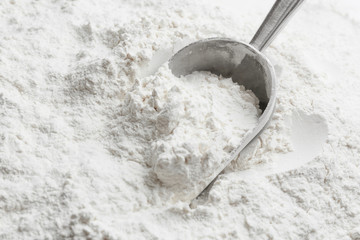 Metal scoop in flour, closeup