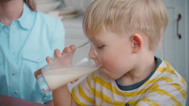Mom Son Spend Time Holiday Eating Breakfast, mother and boy child on kichen, happy family, child eating milk corn flakes
