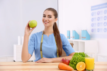 Young female nutritionist in her office