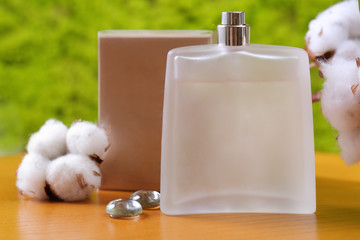 Obraz premium Bottle with perfume on wooden table against blurred background