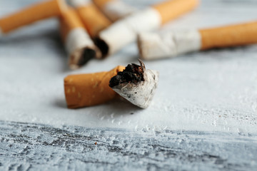 Cigarette butts on wooden background