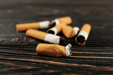 Cigarette butts on wooden background