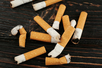 Cigarette butts on wooden background