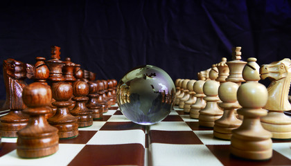 Chess figures against earth globe - obrazy, fototapety, plakaty