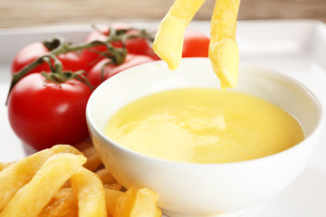 Delicious french fries with cheese sauce, closeup