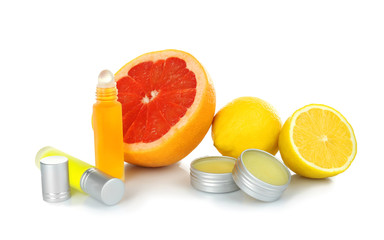 Bottles and containers with perfume near fresh citrus fruits on white background