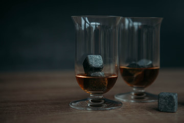 Stones for cooling whiskey and glases tulup on dark wooden background