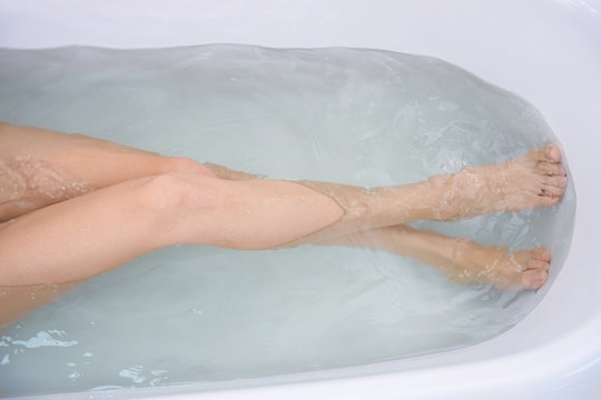 Legs of beautiful young woman taking bath at home