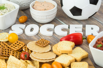 Party table for soccer game with variety of snacks and dips.