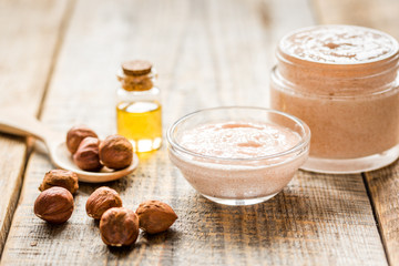 cosmetic set with hazelnut scrub on table background