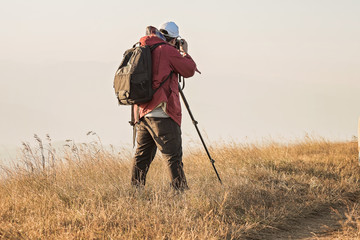 Handsome young professional photographer taking photos,
