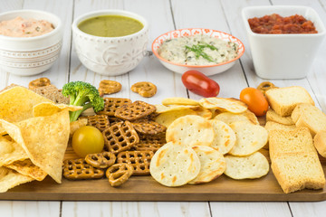 Variety of snacks with dips and salsa.