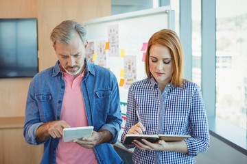Male executive using digital tablet with colleague