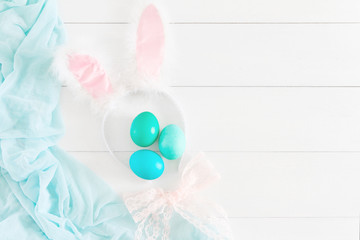 Colorful easter eggs and rim hare ears on a white background. Space for text.