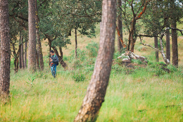 Old man holding camera and walking in phu soi dao, Uttaradit, Thailand.