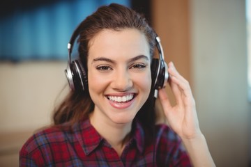 Female graphic designer listening music on headphones