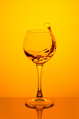 Splash of water in a glass on yellow