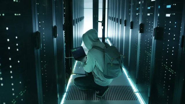  Hacker With Notebook Breaking into Corporate Data Center and Connecting to It's Server. Shot on RED EPIC-W 8K Helium Cinema Camera.