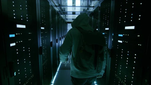 Back View of a Hacker Sneaking in Corporate Data Center.  Shot on RED EPIC-W 8K Helium Cinema Camera.