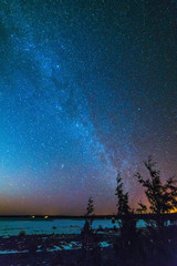 Frozen Lake Huron in winter at night with the milky way and stars