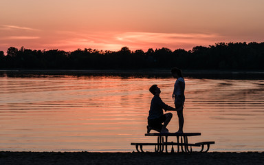 Fototapeta na wymiar A man and a women are enjoying a passionate moment under sunset