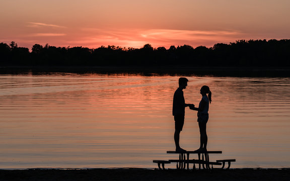 A man and a women are enjoying a passionate moment under sunset