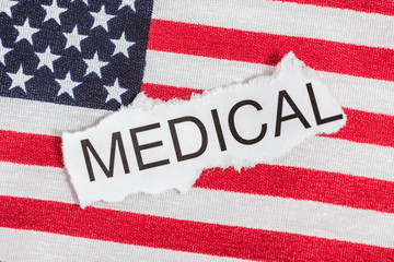 Fototapeta na wymiar Word medical in torn paper on top of American Flag