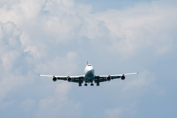 Heavy aircraft fly in front of rain cloud