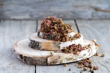 Pile of dried fruit stems are strawberry on a wood background. Selective focus