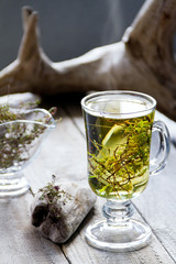 Cup of fresh herbal tea (Dried  Thymus) on wooden table.  Selective focus.