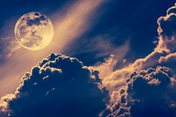 Nighttime sky with clouds and bright full moon with shiny.  Vintage tone effect.