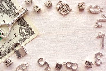 A lock and old key on a one dollar banknote and a frame of metal characters, letters and numbers