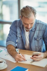 Male business executive writing in organizer 