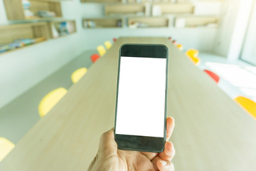 Blank screen mobile phone with woman hand and Library Background
