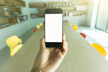 Blank screen mobile phone with woman hand and Library Background