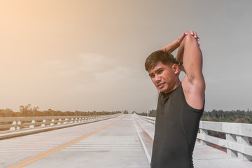 handsome man doing exercises and warm up before run and Physical fitness test ; Healthy lifestyle cardio together at outdoors summer 