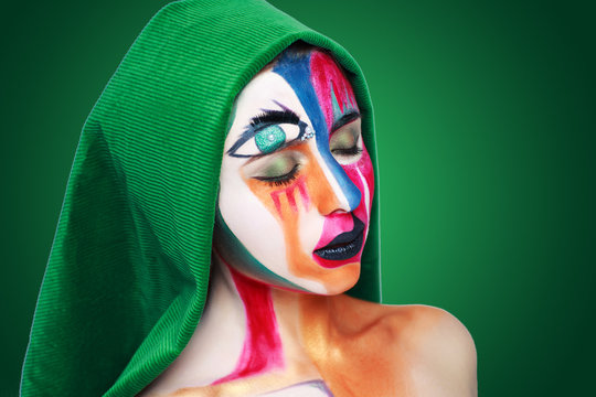 Creative make-up new conceptual idea. blue gold golden green red white bold body art painting. Crazy new graphic abstract picture on woman face surrealistic. professional photo. Creativity art lines