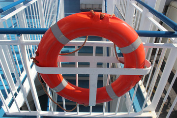 orange life buoy on the railing of a ship