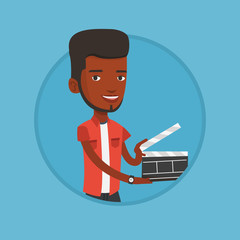 Smiling man holding an open clapperboard.