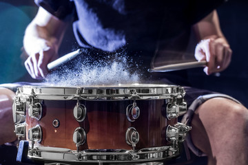 man plays musical percussion instrument with sticks, a musical concept, beautiful lighting on the stage
