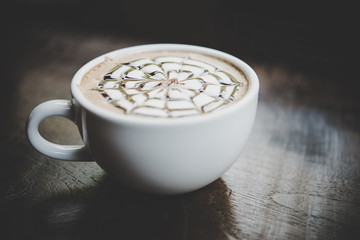 A cup of coffee on wooden table in cafe.
