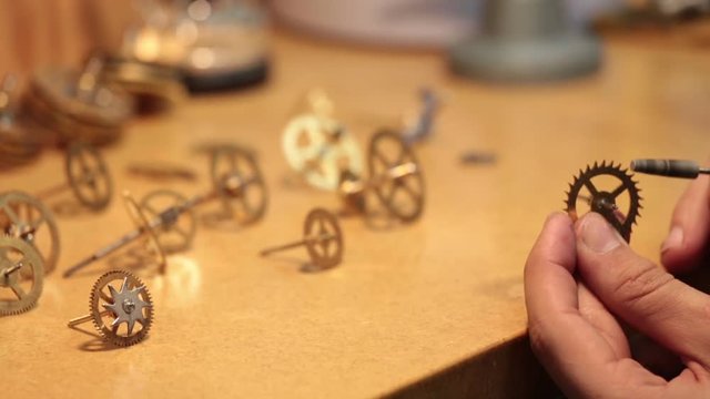 Clockmaker Closeup Working on Gears of Clocks and Timing Gearwork Horologist Occupation