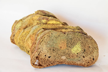 Slices of old moldy rye bread on white background