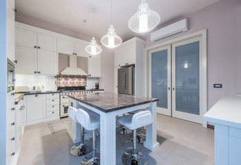 Kitchen Interior with Island, Sink, Cabinets,Tiled Floors in New Luxury Home