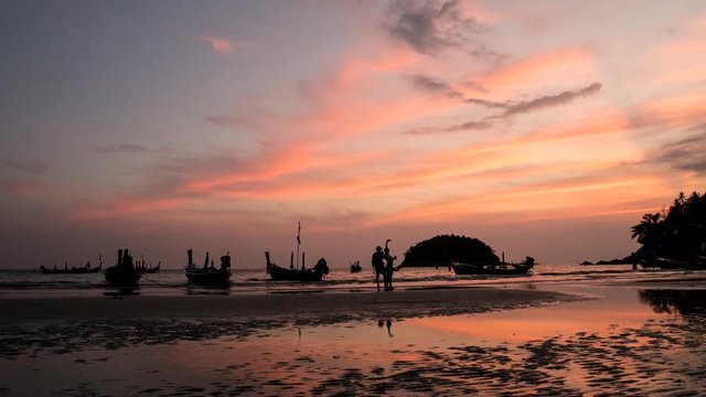 4K Time - lapse group of long tail boat with sunset at kata bech , PHUKET THAILAND