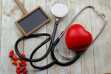 Conceptual with stethoscope and red heart shape on wooden background