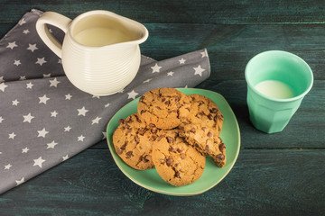 Chocolate chips cookies with glass and jar of milk